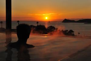 露天風呂から見た沈む夕陽と立神岩
